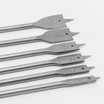 Kit de ferramentas para madeira: serrote, serrinha e jogo de brocas chatas. Imagem detalhada das brocas chatas em aço, com diferentes tamanhos, parte do kit para marcenaria e trabalhos em madeira.