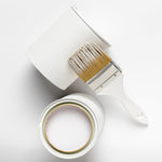 Dióxido de Titânio SR-2377 Pigmento Branco 500g Rutilo - Imagem de lata de tinta branca aberta com pincel, ideal para pintura e artesanato, mostrando a tonalidade e consistência do pigmento.