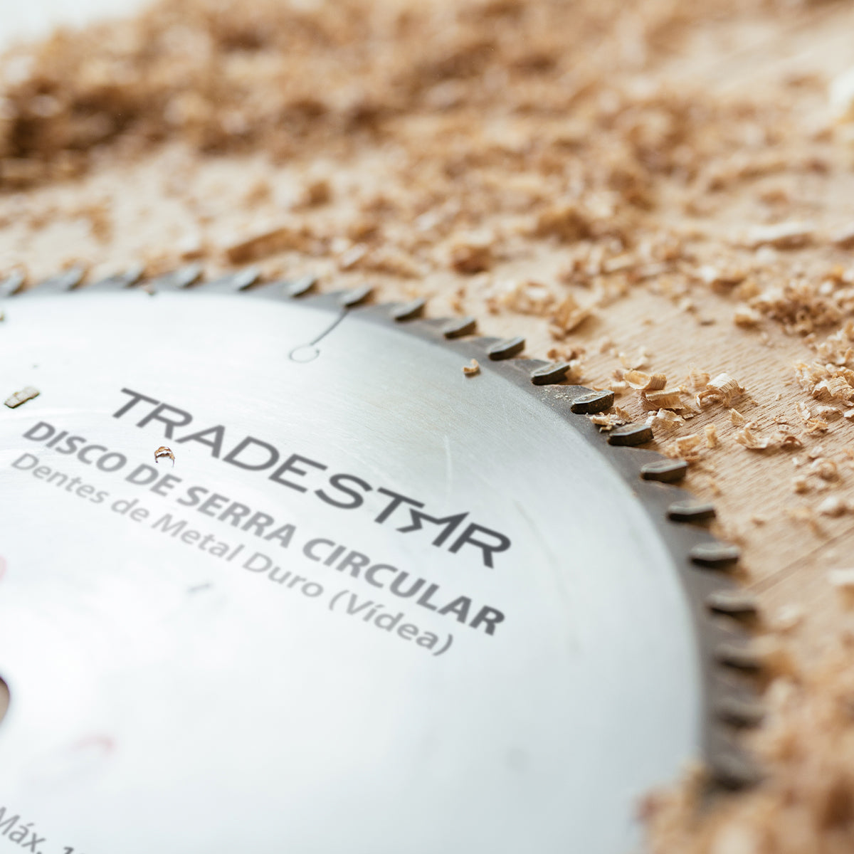 Disco de serra circular para madeira Makita 180x20mm com 40 dentes, ideal para cortes precisos em projetos de marcenaria e carpintaria. Lâmina de alta qualidade para corte rápido e eficiente em diversos tipos de madeira. A imagem mostra a lâmina com detalhes dos dentes e serragem de madeira ao redor.