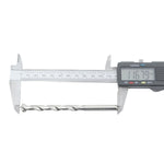 Broca para concreto 10x120mm sendo medida com paquímetro digital, mostrando o comprimento de 116.79mm. Kit com 50 unidades, ideal para furadeira, uso em alvenaria, pedra e concreto. Ferramenta Tradestar, ponta de metal duro, diâmetro de 10mm.