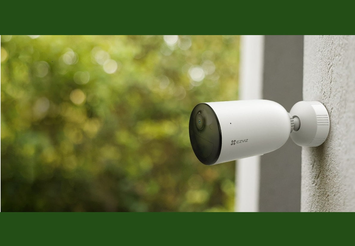 Câmera Externa Bateria EZVIZ CS-CB3 1080P H265 instalada em parede, com design à prova de intempéries, ideal para segurança residencial. Apresenta visão noturna colorida, detecção de movimento humano e integração com assistentes virtuais.