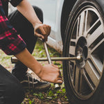 Chave de roda cruz universal Tradestar sendo utilizada para soltar os parafusos de uma roda de carro. Ferramenta automotiva para troca de pneus e manutenção de veículos.