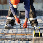 Kit Arame Recozido Trançado e Alicate Torquês Armador em uso na construção civil. Pedreiro utilizando o alicate para amarrar as barras de aço, demonstrando a aplicação do produto em obra, garantindo a segurança e estrutura da construção.