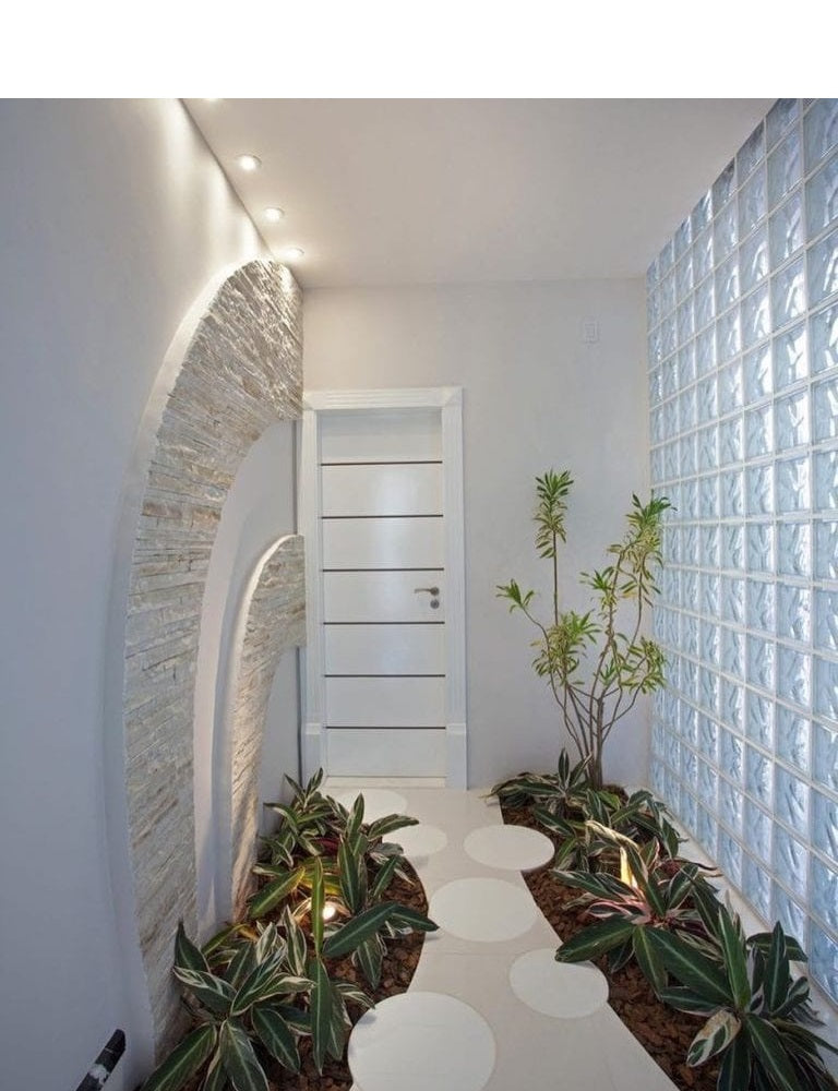 Ambiente interno com parede de tijolos de vidro Tradestar, proporcionando iluminação natural e design moderno. Kit com 6 blocos de vidro estrelas 19x19x8 ideal para divisórias e paredes, com entrega garantida e nota fiscal.