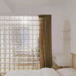 Kit 12 Tijolos Bloco De Vidro Rajada Opaca 19x19x8 Tradestar em parede, ideal para divisórias e iluminação natural em ambientes internos e externos. Veja a aplicação em quarto com cortina e decoração.