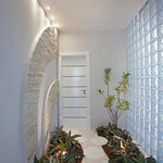 Ambiente interno com parede de tijolos de vidro Tradestar rajada opaca, ideal para divisórias e iluminação natural, kit com 12 unidades, 19x19x8cm, proporcionando claridade e design moderno.